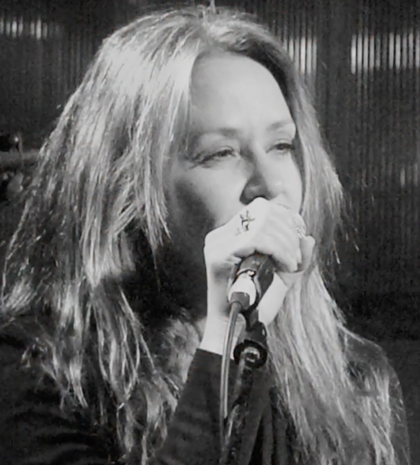 Tal singing into a handheld microphone